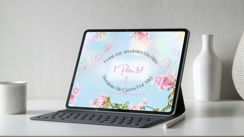 Tablet on a stand showing the 1 Peter 5:7 Christian wallpaper with its floral design